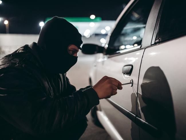 Caucasian man with ski mask stealing a car at night. picture istock