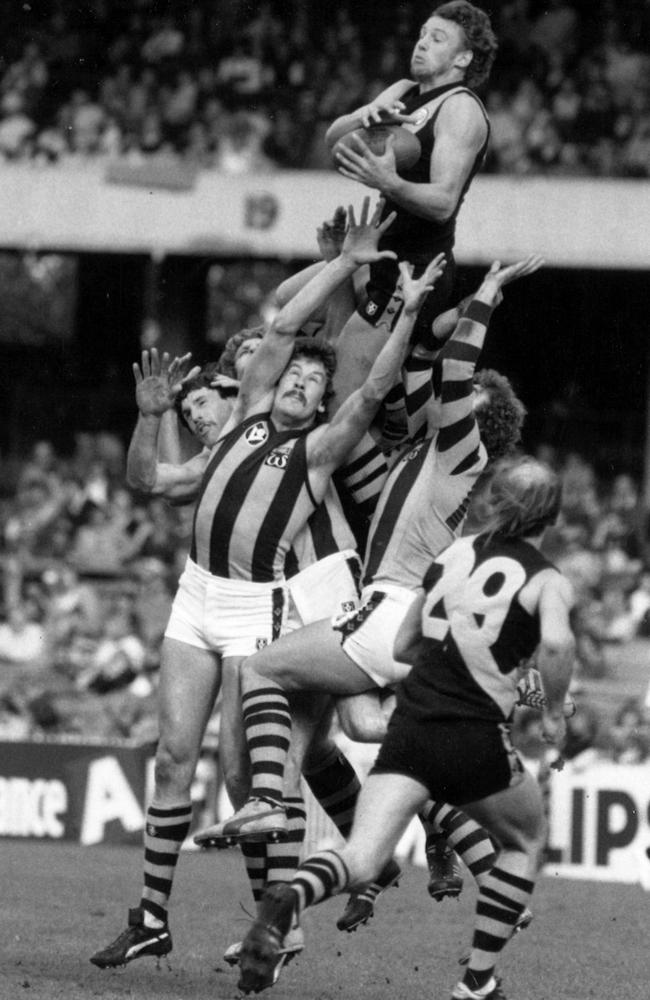 Michael Roach flies over Terry Moore and Kelvin Moore as Kevin Bartlett looks on.