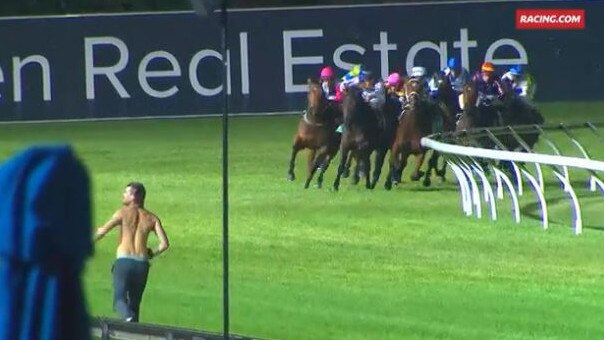 A spectator runs down the track during a race at Cranbourne.