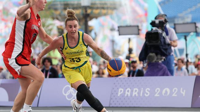 Australia's #33 Lauren Mansfield dribbles past Canada's #02 Katherine Plouffe (L) in the women's pool round 3x3 basketball game between Australia and Canada during the Paris 2024 Olympic Games at La Concorde in Paris on July 30, 2024. (Photo by David GRAY / AFP)