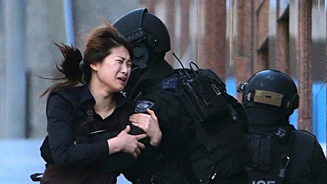 Bae Jie-un runs into the arms of waiting police. (AP Photo/Rob Griffith)