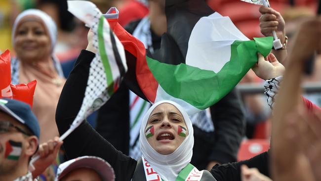 Palestinian fans cheer before their Group D football match against Japan.