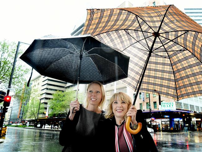 Wet weather in the CBD. Roxanne Crook and Bernadette Libby duck for cover under their umbrellas. Picture: Roy Van der Vegt