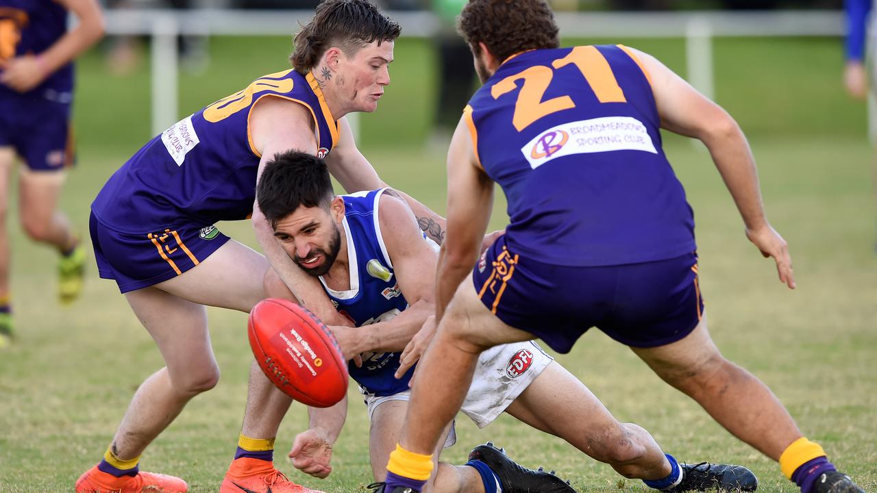 Essendon District: Coburg Districts’ George Pilipasidis flicks the ball out under pressure from Tom Butler and Nathan Walker of Jacana. Picture: Steve Tanner