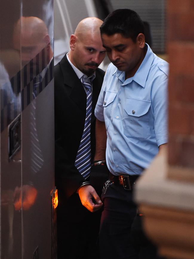 Nicholas Lambaditis being escorted to a prison van after being sentenced to 6 years and 9 months for manslaughter in Sydney, Friday, June 12, 2015. Lambaditis pleaded guilty to the manslaughter of Brazilian Lucio Stein Rodrigues after a fatal on-punch hit in November 2013. (AAP Image/Dean Lewins)