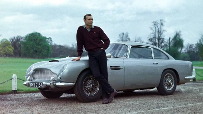 Sean Connery stands in front of an Aston Martin DB5 on the set of the James Bond film “Goldfinger” in 1964. Photo: Everett Collection