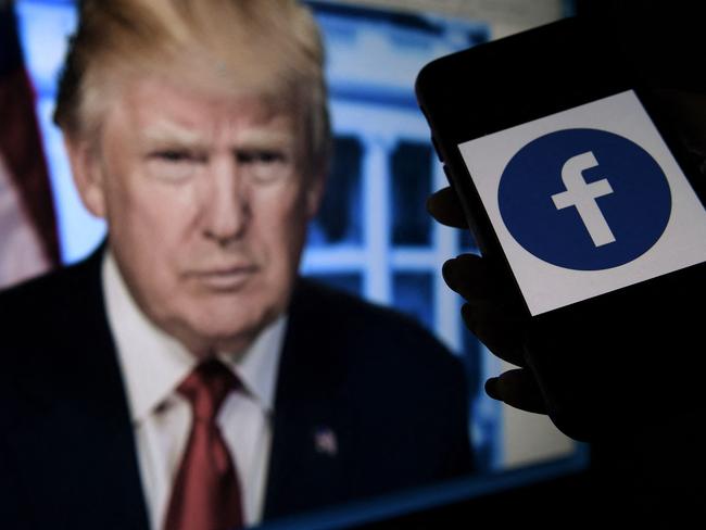 (FILES) In this file photo  illustration, a phone screen displays a Facebook logo with the official portrait of former US President Donald Trump on the background, on May 4, 2021, in Arlington, Virginia. - Facebook's independent oversight board on May 5, 2021 upheld the platform's ban on former US president Donald Trump but called for a further review of the penalty within six months. The board, whose decisions are binding on the leading social network, said Trump "created an environment where a serious risk of violence was possible" with his comments regarding the January 6 rampage by his supporters at the US Capitol. (Photo by Olivier DOULIERY / AFP)