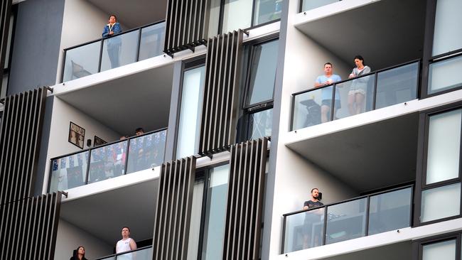 Residents on their balcony's watching the service. “Driveways at Dawn” initiative throughout Hamilton Reach Community spirit drives range of ANZAC Day 2020 celebrations despite COVID-19 restrictions. Saturday April 25, 2020. (AAP image, John Gass)
