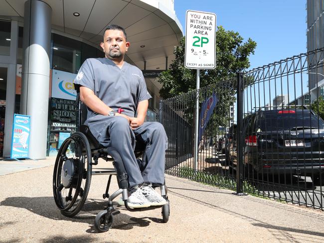 Dr Dinesh Palipana in front of a council parking sign. Picture: Glenn Hampson.