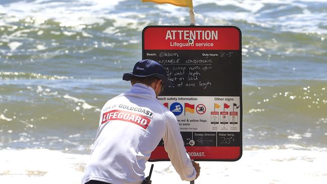 A lifeguard putting out signage after Mr Caserta had been missing for 12 hours. Picture: Adam Head