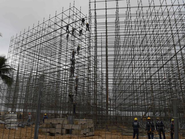 Workers set up the structure for the Arena Olimpica beach court in Copacabana beach where the Olympic beach volleyball tournament is set to be held.