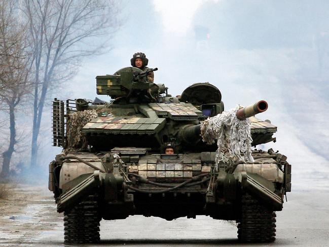 Ukrainian servicemen ride on tanks towards the front line with Russian forces in the Lugansk region of Ukraine. Picture: AFP