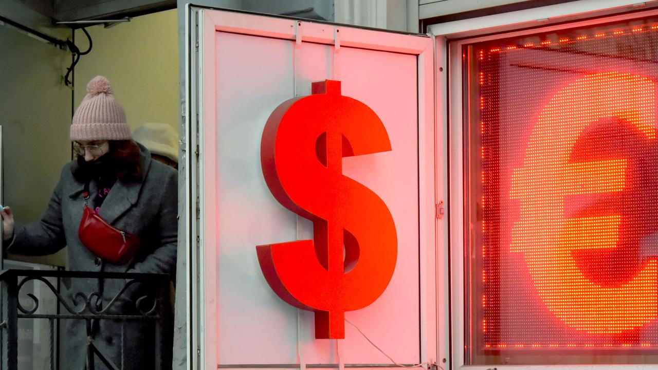 A woman leaves a currency exchange office displaying the US dollar and the euro signs in Saint Petersburg. Picture: Olga Maltseva / AFP