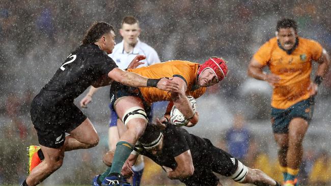 Harry Wilson of the Wallabies is tackled by Luke Jacobson and David Havili of the All Blacks during The Rugby Championship and Bledisloe Cup match between the New Zealand All Blacks and the Australian Wallabies at Eden Park on August 14, 2021 in Auckland, New Zealand. (Photo by Anthony Au-Yeung/Getty Images)