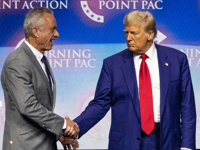 (FILES) Former US President and Republican presidential candidate Donald Trump (2nd L) shakes hands with US politician Robert F. Kennedy Jr. as he invites him former US Representative Tulsi Gabbard (R) and US commentator Tucker Carlson onto the stage during a campaign rally at the Gas South Arena in Duluth, Georgia, on October 23, 2024. US President-elect Donald Trump announced on Thursday that he is nominating Kennedy to be the US Secretary of Health and Human Services. (Photo by CHRISTIAN MONTERROSA / AFP)