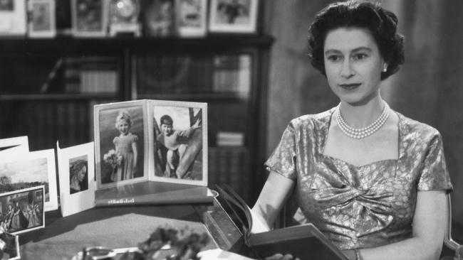 The Queen Elizabeth at her desk dessed in a gold lame dress, shortly after giving her first Christmas Day TV and radio broadcast. Picture: Getty Images.