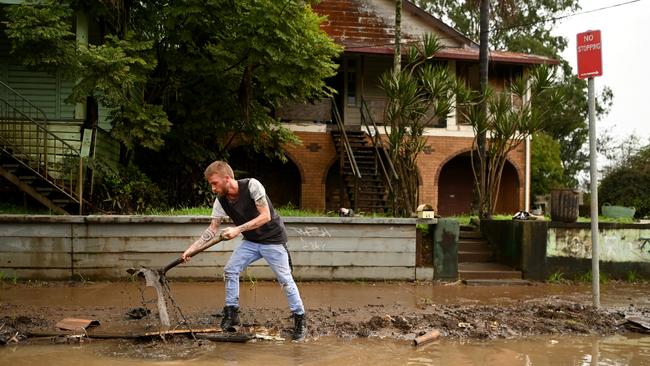 Eli Roth clears mud and debris from a drain in his street on March 29, 2022. Picture: Dan Peled/Getty Images