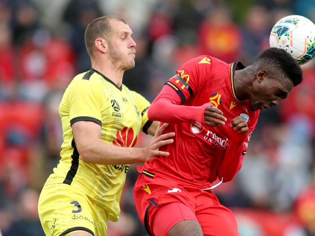 Wellington’s Luke DeVere (left) battles with Adelaide United’s Al Hassan Toure. Picture:AAP Image/Kelly Barnes