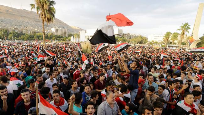 Syrians react as they watch a live broadcast of the first leg of the FIFA World Cup 2018 qualifier football match between Syria and Australia in Damascus' Umayyad Square on October 5, 2017. Syria drew with Australia 1-1. / AFP PHOTO / LOUAI BESHARA