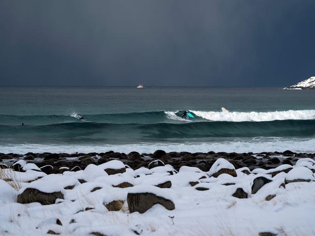 A surfers rides a wave after a sudden snowfall on March 11, 2018 in Unstad, northern Norway, Lofoten islands, within the Arctic Circle. Picture: AFP