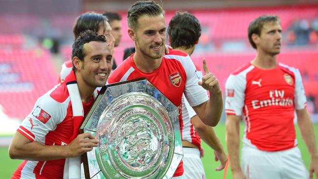 (L-R) Arsenal's Spanish midfielder Santi Cazorla and Arsenal's Welsh midfielder Aaron Ramsey pose with the Community Shield trophy after Arsenal won the FA Community Shield football match between Arsenal and Manchester City at Wembley Stadium in north London on August 10, 2014. AFP PHOTO / CARL COURT -- NOT FOR MARKETING OR ADVERTISING USE / RESTRICTED TO EDITORIAL USE