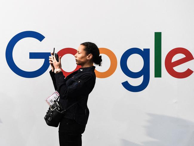 (FILES) In this file photo a woman takes a picture with two smartphones in front of the logo of the US multinational technology and Internet-related services company Google as she visits the Vivatech startups and innovation fair, in Paris on May 16, 2019. - Google has agreed to make "significant payments" to Rupert Murdoch's News Corp. for content, the companies said on February 17, 2021 as tech firms face growing pressure to pay for news from an Australian-led initiative. (Photo by ALAIN JOCARD / AFP)