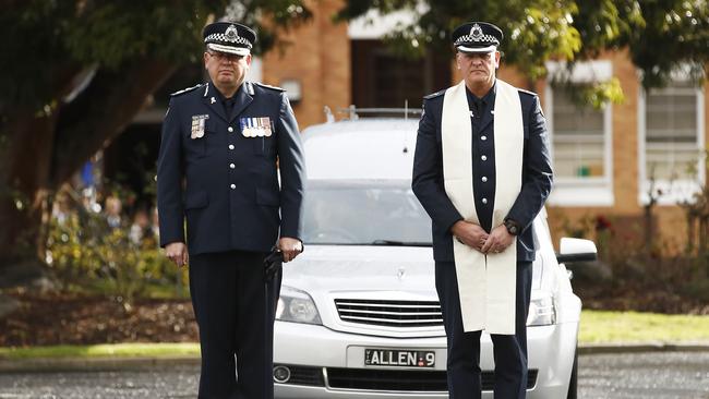 Victoria Police Chief Commissioner Graham Ashton (L) and Victoria Police Senior Chaplain Jim Jung lead the hearse out at the funeral