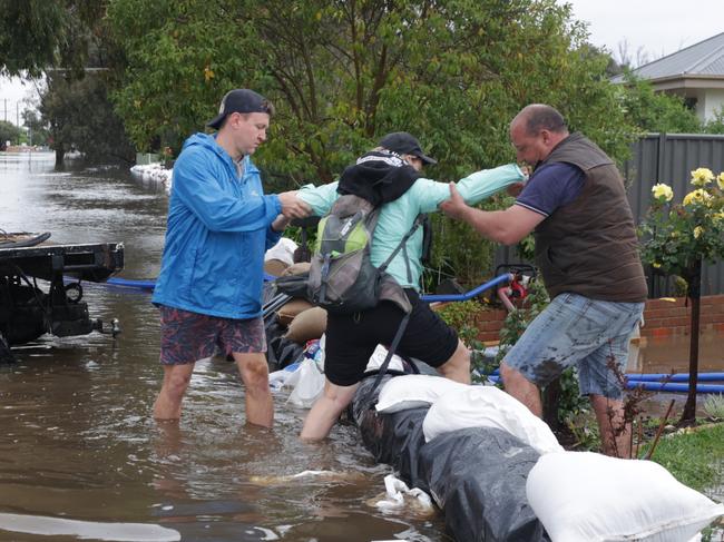 Residents return to their sandbagged homes to fight the flood water. Picture: David Caird