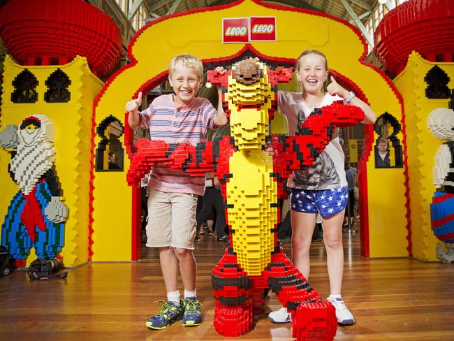 Cousins Ryan Coulter, 10, and Bec Allen, 9, make friends with a giant Tiger at Brickvention, a LEGO convention at the Melbourne Exhibition Building. Picture: Nathan Dyer