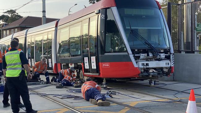 Engineers working to re-rail the light rail tram. Picture: Chris Harris