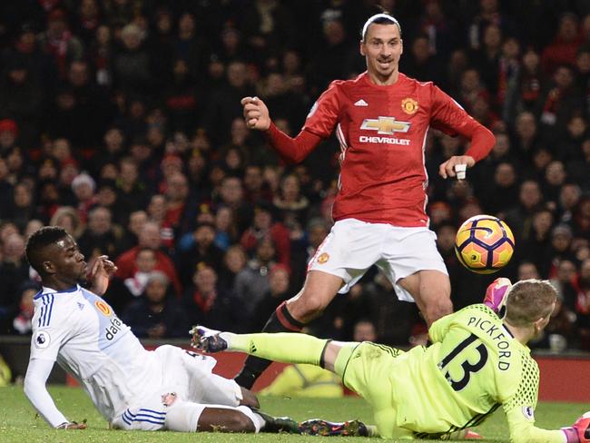 Manchester United's Swedish striker Zlatan Ibrahimovic (C) lifts the ball over Sunderland's English goalkeeper Jordan Pickford (R) to score their second goal during the English Premier League football match between Manchester United and Sunderland at Old Trafford in Manchester, north west England, on December 26, 2016. / AFP PHOTO / Oli SCARFF / RESTRICTED TO EDITORIAL USE. No use with unauthorized audio, video, data, fixture lists, club/league logos or 'live' services. Online in-match use limited to 75 images, no video emulation. No use in betting, games or single club/league/player publications. /