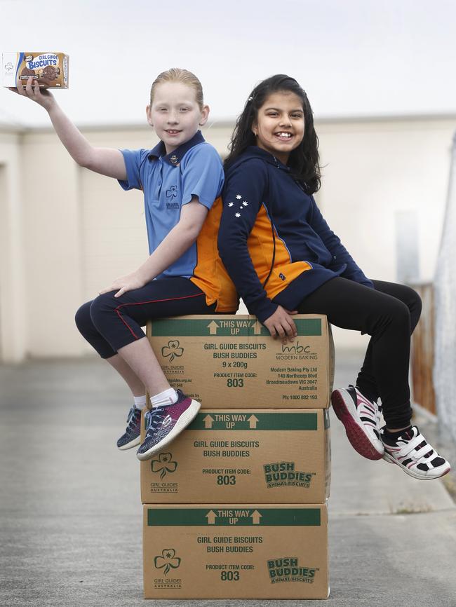 Girl Guides Sarah Potter, left, and Meerab Fatimah, both 9, with some of the Girl Guide biscuits to be donated to FoodBank. Picture: KIM EISZELE