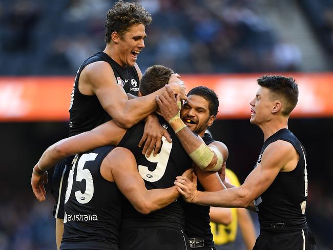 Charlie Curnow (left) jumps onto Patrick Cripps (third from left) of the Blues after Cripps kicked a goal in the last quarter during the Round 12 AFL match between the Carlton Blues and the Brisbane Lions at Marvel Satdium in Melbourne, Saturday, June 8, 2019. (AAP Image/Julian Smith) NO ARCHIVING, EDITORIAL USE ONLY