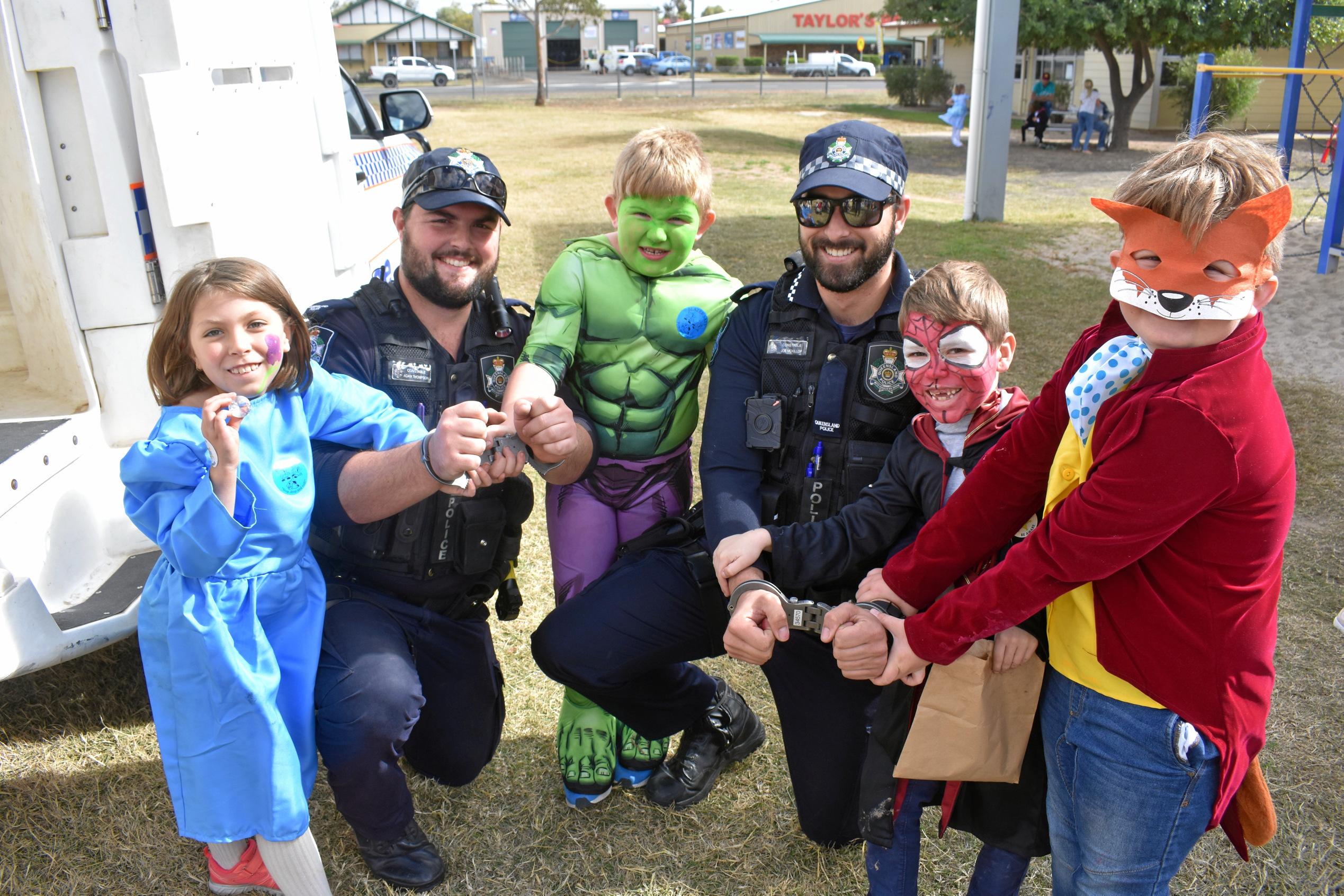 Isabella McDonell, Sterling McDonell, Riley Groves and Kaden Groves 'arrest' local police officers Adam Thompson and Joe McKillop. Picture: Jorja McDonnell