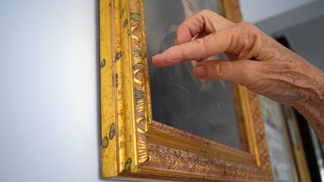 Palmview resident Susan Fry said salt water droplets had left blue marks on the gold frames of her portraits. She believes this is evidence of a concerning level of moisture in her home. Picture: Zizi Averill