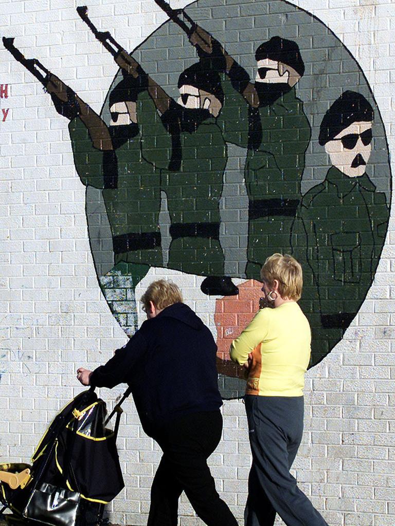 Belfast residents pass an IRA mural in 2001. This type of artwork was once commonplace.