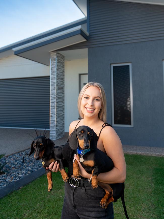 Kate Johnson was a beneficiary of the BuildBonus program, buying her first house in Zuccoli, Darwin at just 21. Picture: Kate is pictured with her two dogs Ollie and Bentley three weeks after moving in to her new home. Picture: Che Chorley