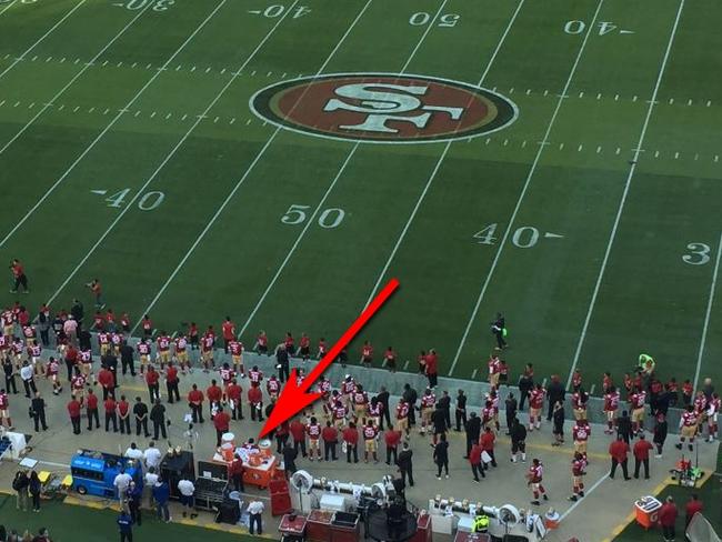 Kaepernick can be seen here, seated between the orange water dispensers while the US national anthem plays. Picture: Twitter / @jenniferleechan