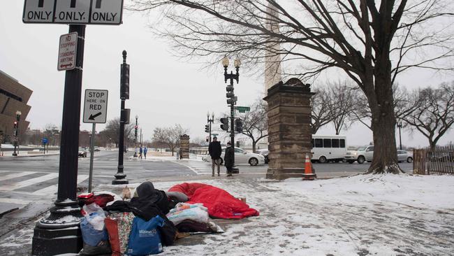 A homeless man sits on a steam grate for warmth. The homeless have little to no protection from COVID-19. Picture: AFP