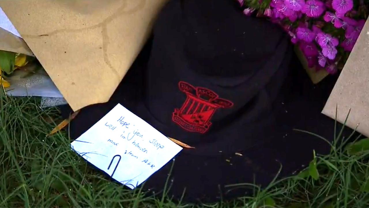 A school hat with a note reading, ' I hope you sleep well in heaven Max' is one of a handful tributes piled up outside the Brisbane home. Picture: Supplied/Nine News