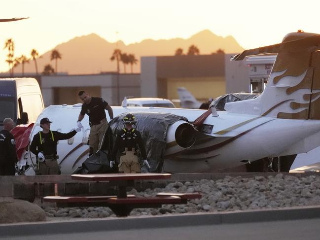 Scottsdale Fire Department firefighters work on the crashed Learjet at Scottsdale Airport. Picture: AP