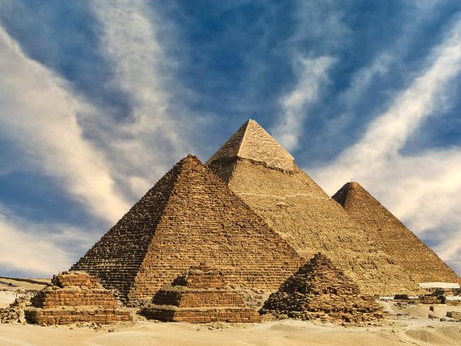 "Egypt. Cairo - Giza. General view of pyramids from the Giza Plateau (from left: the Pyramid of Menkaure /Mykerinos/, Khafre /Chephren/ and Chufu /Cheops/ - known as the Great Pyramid and three small pyramids popularly known as Queens' Pyramids on front side). The Pyramid Fields from Giza to Dahshur is on UNESCO World Heritage List"