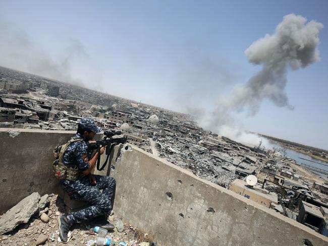 An Iraqi forces sniper looks on as smoke billows, following an air strike by US-led international coalition forces targeting Islamic State (IS) group, in the Old City of Mosul. Picture: Ahmad al-Rubaye/AFP