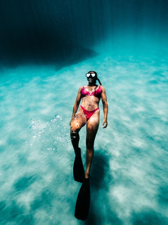 Cassie Staples next to a cloud of underwater ash at her hometown of Batemans Bay. Picture: Joshua Burkinshaw