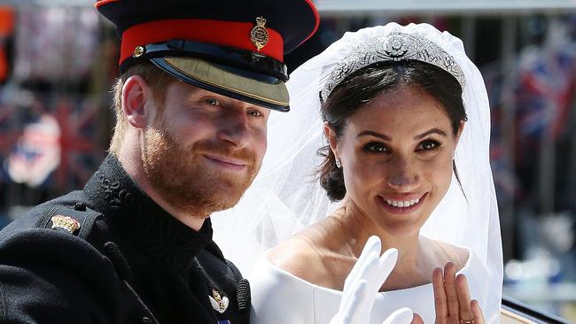 (FILES) In this file photo taken on May 19, 2018 Britain's Prince Harry, Duke of Sussex and his wife Meghan, Duchess of Sussex wave from the Ascot Landau Carriage during their carriage procession on the Long Walk as they head back towards Windsor Castle in Windsor, oafter their wedding ceremony. - Britain's Prince Harry and his wife Meghan will step back as senior members of the royal family and spend more time in North America, the couple said in a historic statement Wednesday. (Photo by Aaron Chown / POOL / AFP)