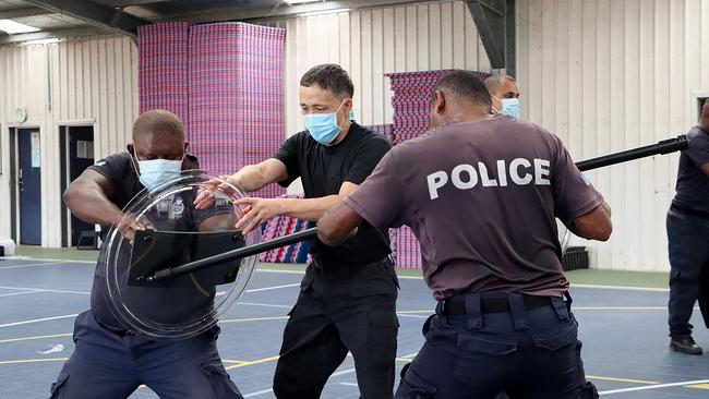 China Police Liason Team officer trains Solomon Islands police officers in unarmed combat and rifle tactics. Picture: AFP.