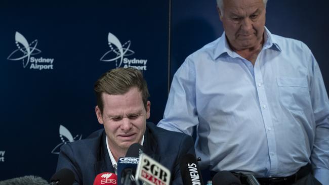 Dumped Australian captain Steve Smith is comforted by his father Peter at the press conference at Sydney airport on Thursday night.