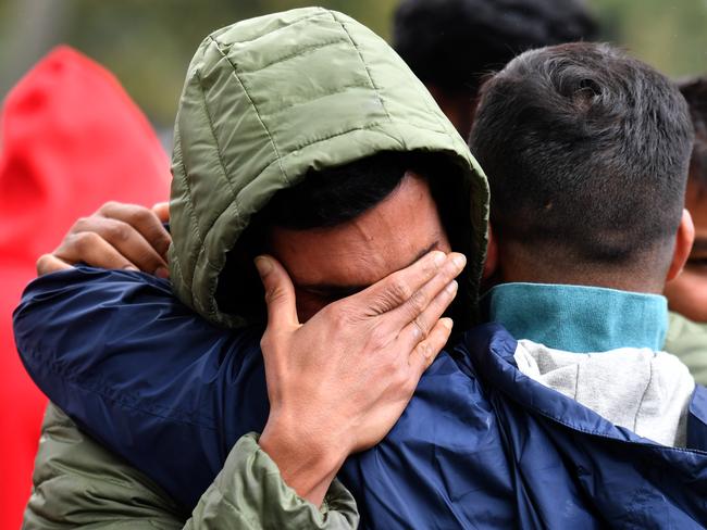 Friends of a missing man grieve outside a refuge centre in Christchurch. Picture: AAP