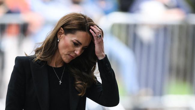 Kate took a moment to reflect as she looked at the tributes (Photo by Daniel LEAL / AFP)