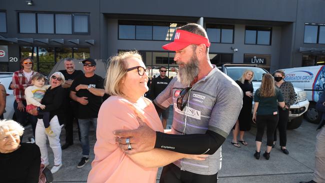 Ex-firefighter and terminal Parkinson battler Jason Williams gets a hug from his wife Tina after returning from a 1400 fundraising bicycle trip from the Gold Coast to Newcastle. Picture Glenn Hampson